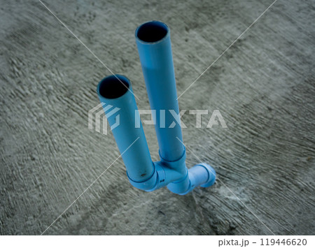 A bright blue pipes attached to a solid concrete wall A bright blue pipes attached to a solid concrete wall 119446620