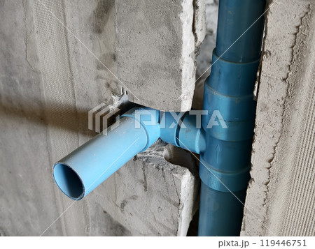 A bright blue pipes attached to a solid concrete wall A bright blue pipes attached to a solid concrete wall 119446751