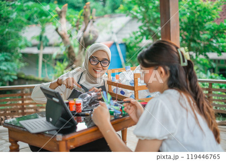 asian women watching upcycling plastic bottle tutorial in tablet 119446765