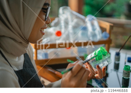 close up hijab woman coloring plastic bottle waste close up hijab woman coloring plastic bottle waste 119446888