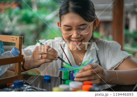 asian woman painting craft made from plastic bottle waste 119446893