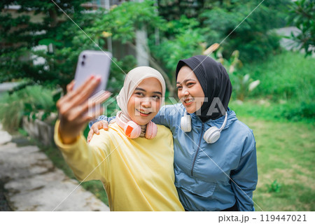 A Group of Happy Friends Enjoying Taken a Selfie Together in a Green Park 119447021