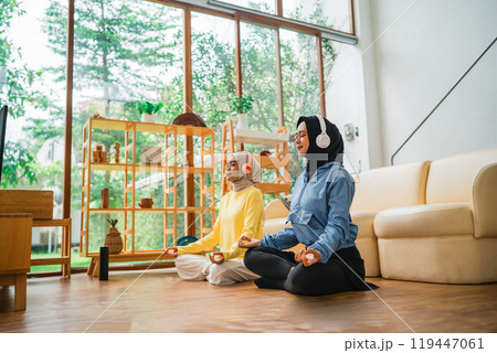 Engaging in a Mindfulness Meditation Session at Home with Two Practitioners Engaging in a Mindfulness Meditation Session at Home with Two Practitioners 119447061