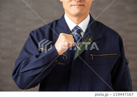 握り拳でガッツポーズをする作業着姿のミドル男性ビジネスマン 119447167
