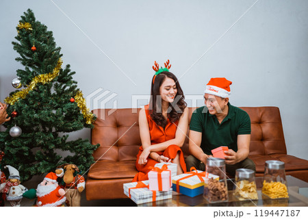 A joyous and festive couple joyfully celebrating Christmas with gifts, love, and cheer 119447187