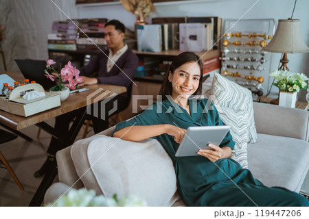 beautiful shop owner looking at the camera while working on her tablet beautiful shop owner looking at the camera while working on her tablet 119447206