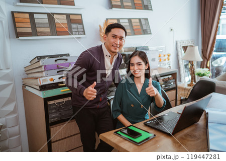 couple of asian interior shop crew looking at camera with thumbs up couple of asian interior shop crew looking at camera with thumbs up 119447281