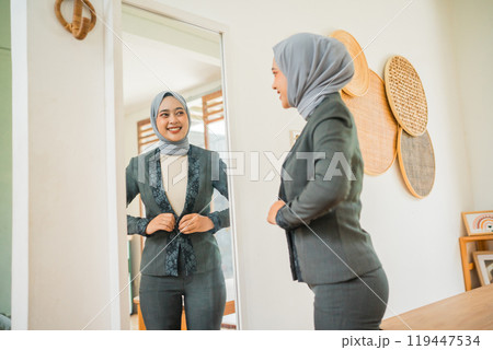 attractive veiled young woman wearing a blazer in front of a mirror 119447534