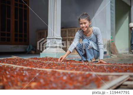 A Young Girl Engaged in Working with Colorful Dried Fruits in a Traditional Setting A Young Girl Engaged in Working with Colorful Dried Fruits in a Traditional Setting 119447791