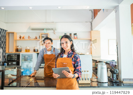 beautiful woman shop owner wearing apron smiling holding a tablet beautiful woman shop owner wearing apron smiling holding a tablet 119447829