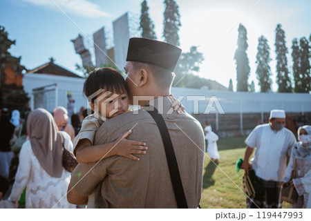 A father lovingly embraces his child at a vibrant community event, celebrating joy A father lovingly embraces his child at a vibrant community event, celebrating joy 119447993