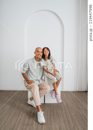 A man and a girl sit next to each other on a bench 119447996