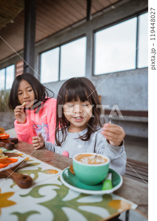 A group of children happily enjoying breakfast together in a cozy, inviting setting A group of children happily enjoying breakfast together in a cozy, inviting setting 119448027