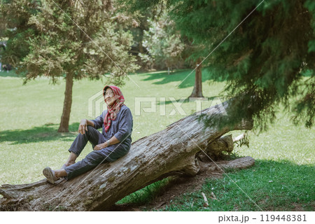 Enjoy a serene moment in nature on a fallen tree, appreciating outdoor peace Enjoy a serene moment in nature on a fallen tree, appreciating outdoor peace 119448381