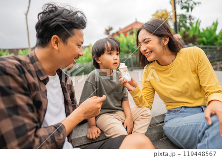 little boy daydreaming while feeding mom ice cream while playing with dad 119448567