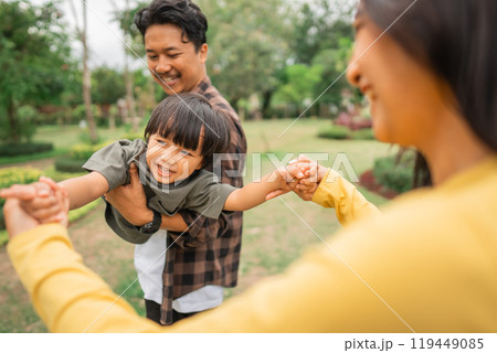woman holds both hands of a boy while being carry by a man 119449085
