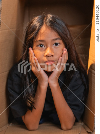 Thoughtful Child in a Cardboard Box A Beautiful Moment of Deep Reflection 119449120