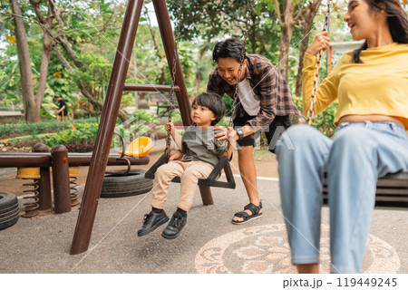 small child together man and woman toy swing together 119449245