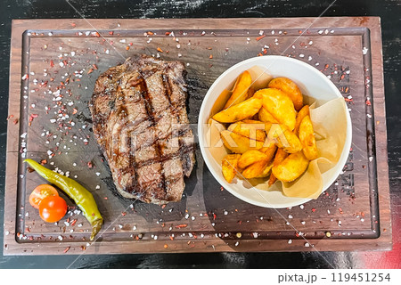 Fresh grilled meat. Grilled beef steak medium rare on wooden cutting board. Top view. Fresh grilled meat. Grilled beef steak medium rare on wooden cutting board. Top view. 119451254