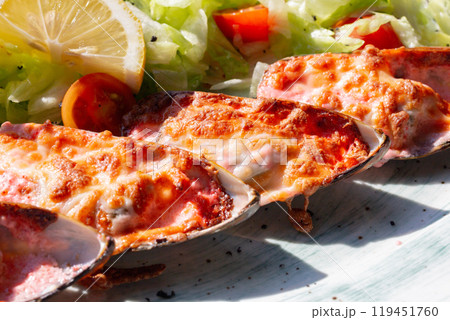 baked mussels with masago caviar and cheese on a white plate baked mussels with masago caviar and cheese on a white plate 119451760