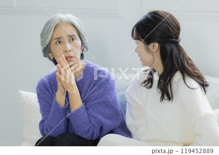 リビングで喧嘩をするシニア女性と若い女性 リビングで喧嘩をするシニア女性と若い女性 119452889