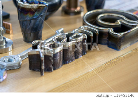 Model printed on 3D printer from metal. Object created on 3D printer from melting metal thread. Modern new technologies. Additive progressive manufacturing solution. Metal 3d printing technology Model printed on 3D printer from metal. Object created on 3D printer from melting metal thread. Modern new technologies. Additive progressive manufacturing solution. Metal 3d printing technology 119453146