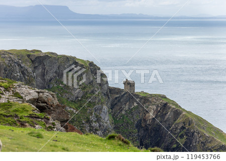 View of rugged cliffs meeting ocean and sky near Slieve League with an old stone structure 119453766