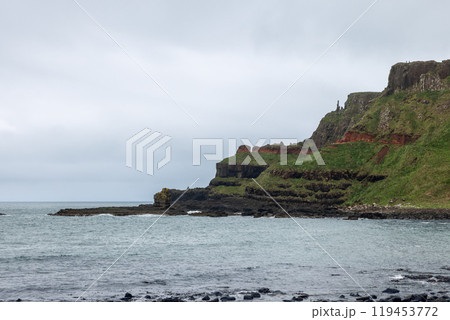 Giant Causeway Amphitheatre headland shows dramatic cliffs and volcanic layers reaching the Atlantic 119453772