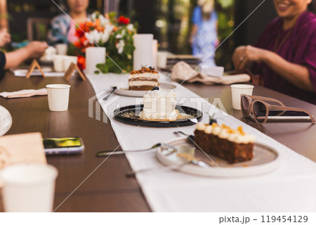 Happy woman and friends enjoy having drink tea or coffee with cakes in cafe. Happy woman and friends enjoy having drink tea or coffee with cakes in cafe. 119454129