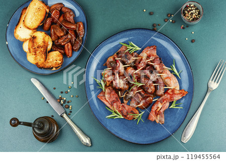A plate of bacon wrapped dates. A plate of bacon wrapped dates. 119455564