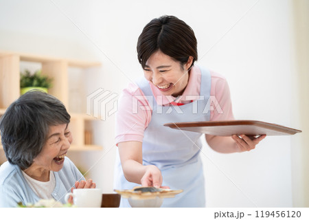 シニア女性に食事を配膳する女性　食事提供 119456120
