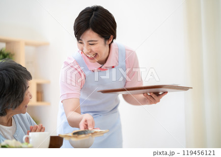 シニア女性に食事を配膳する女性　食事提供 119456121