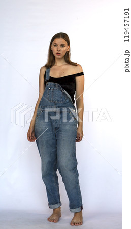 young woman in denim overalls, studio shooting young woman in denim overalls, studio shooting 119457191