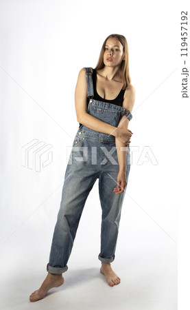 young woman in denim overalls, studio shooting young woman in denim overalls, studio shooting 119457192