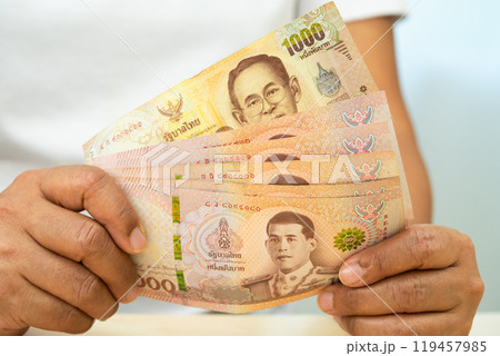 Asian woman holding Thai banknotes money, economy finance exchange trade investment. Asian woman holding Thai banknotes money, economy finance exchange trade investment. 119457985