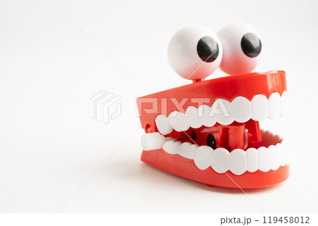 Tooth funny toy denture red color jaw and eye on white background with copy space. 119458012