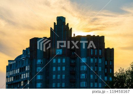 The facade of the building against the backdrop of a bright evening sunset. 119458167
