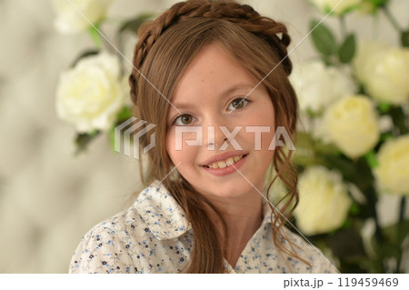 Pretty little girl smiling and posing with flowers 119459469