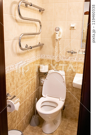 Clean bathroom with white toilet and tiled walls. 119460338