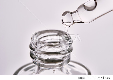 Close-up of a cosmetic bottle with a pipette showing the texture of the serum. 119461835