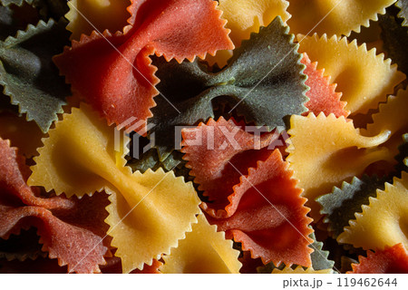 Dry Uncooked Colored Farfalle Pasta and Raw Macaroni on a Textured Background 119462644