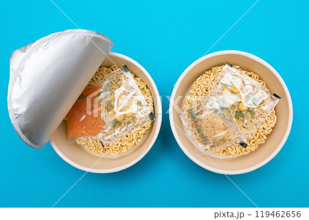 Opened Package with Uncooked Instant Noodles on Blue Background 119462656