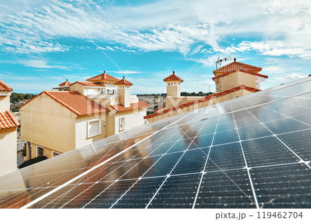 Solar panels installed on red-tiled roofs of residential building on sunny cloudy sky background. Solar panels installed on red-tiled roofs of residential building on sunny cloudy sky background. 119462704