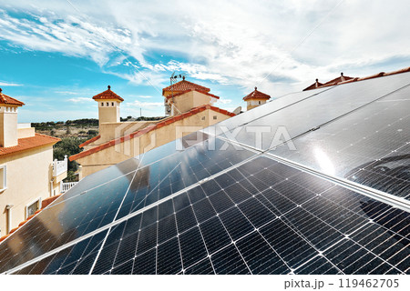 Solar panels installed on red-tiled roofs of residential building on sunny cloudy sky background. Solar panels installed on red-tiled roofs of residential building on sunny cloudy sky background. 119462705