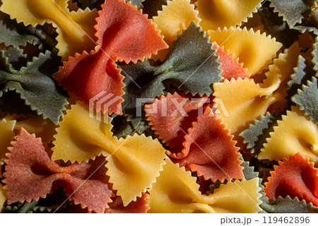 Dry Uncooked Colored Farfalle Pasta and Raw Macaroni on a Textured Background 119462896