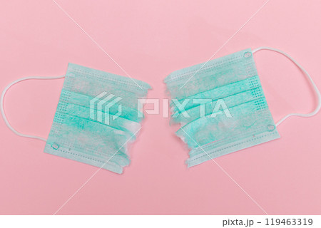 Green Torn Medical Face Mask on the Pink Background Green Torn Medical Face Mask on the Pink Background 119463319