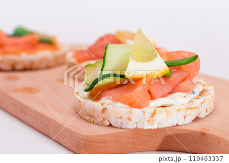 Rice Cake Sandwiches with Fresh Salmon, Cucumber, Lemon and Greens 119463337