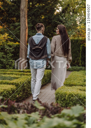 Love, hug and happy with couple in park for romance, bonding and summer vacation. Loving young couple hugging and smiling together on nature background. Beautiful girl with tattooed body outdoor. 119464007