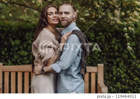 Happy loving couple enjoying their time together in park. Loving couple spending time together. Girl with tattoos. Tattooed woman. Beautiful fashionable couple of lovers on the street. Happy loving couple enjoying their time together in park. Loving couple spending time together. Girl with tattoos. Tattooed woman. Beautiful fashionable couple of lovers on the street. 119464011