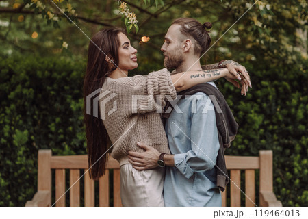Happy loving couple enjoying their time together in park. Loving couple spending time together. Girl with tattoos. Tattooed woman. Beautiful fashionable couple of lovers on the street. Happy loving couple enjoying their time together in park. Loving couple spending time together. Girl with tattoos. Tattooed woman. Beautiful fashionable couple of lovers on the street. 119464013